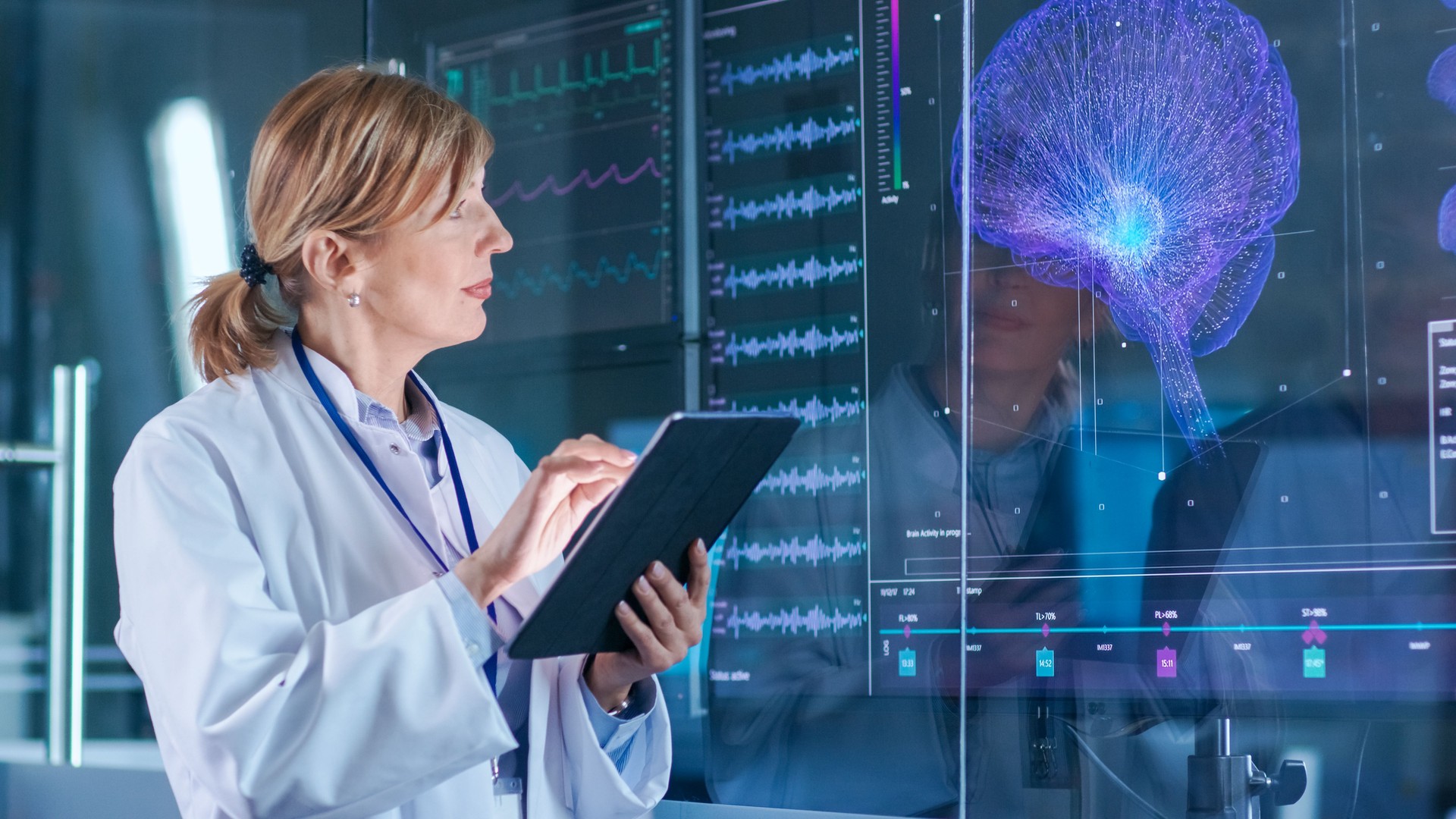 Female Scientist Uses Tablet Computer In the Modern Brain Study Laboratory and Monitors EEG Reading and Brain Model Functioning.